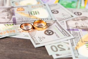 A photograph of wedding bands on top of money.